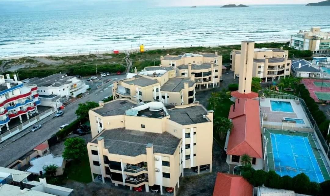 Vista aérea do condomínio Vila Inglesa mostrando os blocos, a rua, a faixa de areia, o mar, a quadra e a piscina