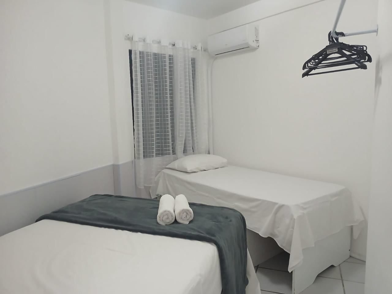 Quarto com duas camas de solteiro separadas, ar-condicionado e cabides
